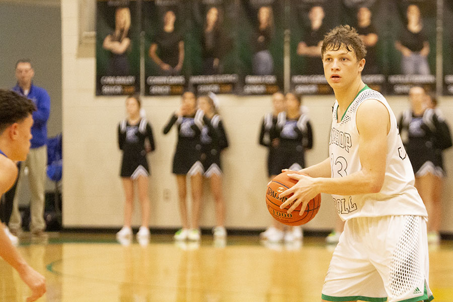 Justin Powell looks for an open man during the Hoops Holy War. Carroll won the rivalry game. Photo by Grace Mernagh.